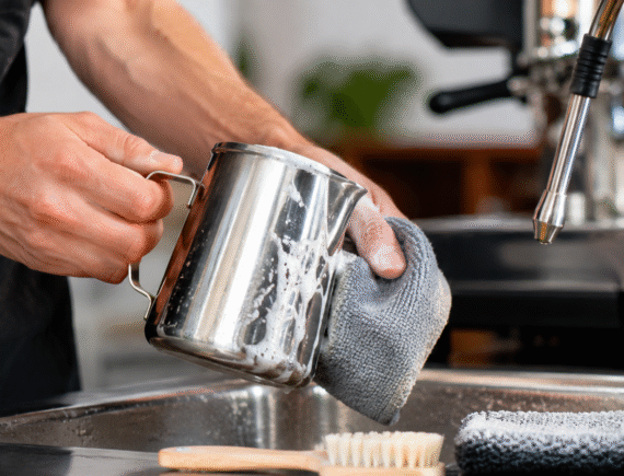 How to clean a coffee milk pitcher with a soft cloth and cleaning brush