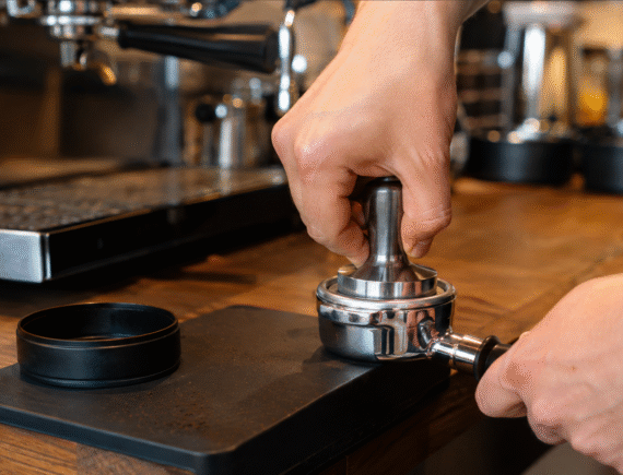 Barista tamping espresso in a portafilter for even and repeatable shots
