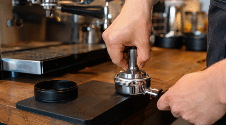 Barista tamping espresso in a portafilter for even and repeatable shots